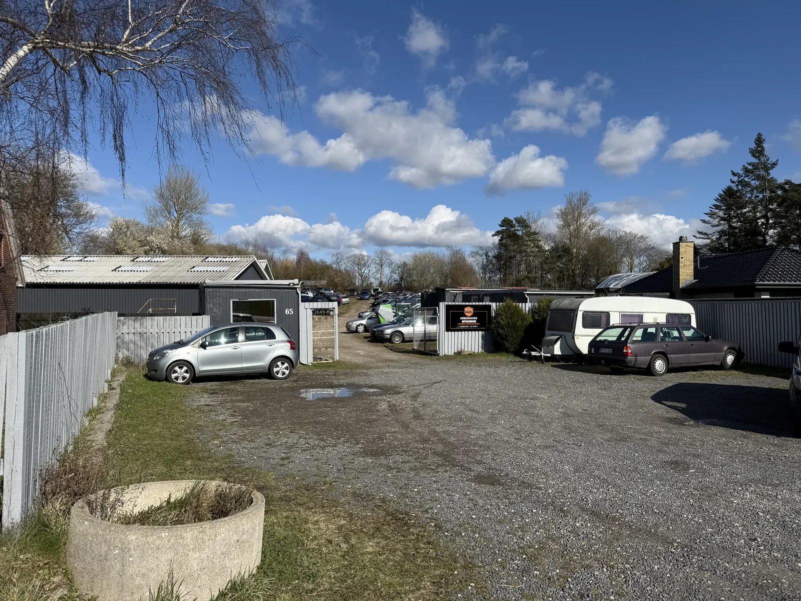 Indkørslen til Københavns Autogenbrug på Ole Rømers Vej 65 med skiltet ved porten og biler på pladsen bagved